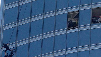 Crew members stand by as Tom Cruise hangs off the Burj Khalifa during filming. Pawan Singh / The National