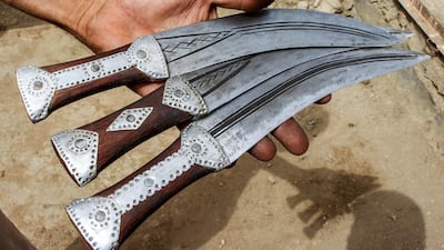 A Yemeni man holds newly-forged daggers.