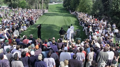 Fans line-up on the 18th hole as Tiger Woods hits a drive during final practice. AFP