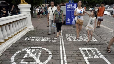 Residents walk along a lane that separate people using their phones from other pedestrians in southwest China's Chongqing Municipality. AP