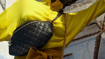 Top and trousers, prices on request, both from Valentino. Belt bag, price on request, Chanel. Crossbody bag, Dh7,950, Saint Laurent