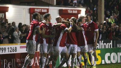 Danny Webber of Salford City is mobbed by teammates in celebration after scoring their opener, eventually the winner against Notts County in the FA Cup. Chris Brunskill / Getty Images