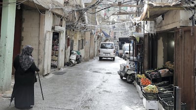 A Palestinian woman walks down a street in the Burj Al Barajneh camp. JOSEPH EID / AFP