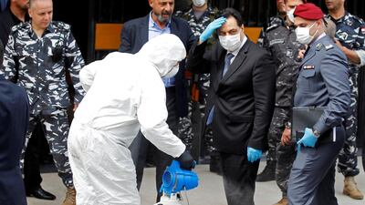 Lebanese Prime Minister Hassan Diab is sprayed with disinfectant as he arrives to attend a legislative session in Beirut. Reuters