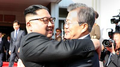 South Korea's President Moon Jae-in (R) hugging North Korea's leader Kim Jong-un today in Panmunjom in the Demilitarised Zone. Dong-A Ilbo / AFP
