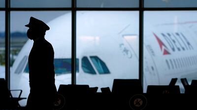 A Delta Airlines pilot wears a face mask as he walks through a terminal at Hartsfield-Jackson International Airport in Atlanta. The aviation industry has experienced a mass departure of skilled workers. AP