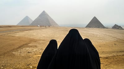 Tourists wearing veils look at the Pyramids of Giza as they stand from across the Giza plateau in Cairo. The much-anticipated opening of the $1bn Grand Egyptian Museum is slated for next year near the pyramids of Giza. AFP