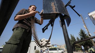 A Kurdish policewoman stands guard as Kurdish and Arab protesters take part in a march against Turkish President Tayip Erdogan and walk to the United Nations Headquarters in the town of Qamishli, Syria. REUTERS