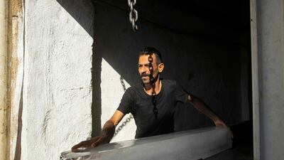 A man takes a block of ice out of an ice factory in Basra. AFP