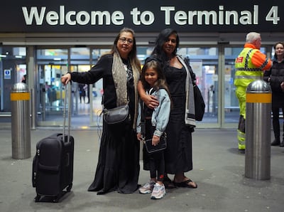 Sisters Hema, left, and Minal Patel, with their niece Saraya Vann, arrive at Heathrow Airport after a stopover in the UAE following a wedding in Thailand. PA