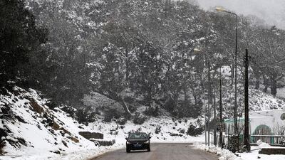 A car drives through falling snow in the city of Ain Draham on the slopes of the Djebel Bir, in Tunisia's northwestern province of Jendouba, about 185 kilometres west of the capital Tunis. AFP