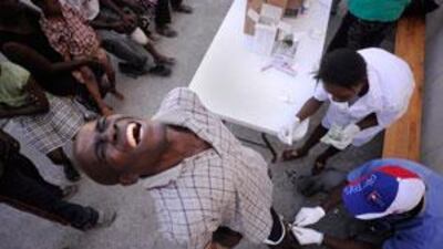 A man has a wound in his leg cleaned at a makeshift field clinic run by the Cuban Medical Battalion in Port-au-Prince.
