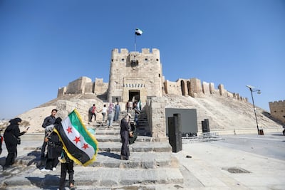 Tourists stand in front of the ancient Citadel of Aleppo. Getty Images