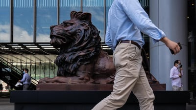 Pedestrians past a statue of a lion in front of the HSBC Holdings Plc headquarters building in Hong Kong. Bloomberg