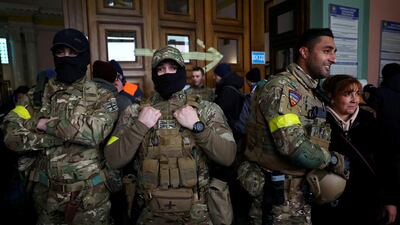 Ben Grant, right, and other foreign fighters from the UK at the main train station in Lviv, Ukraine. Reuters