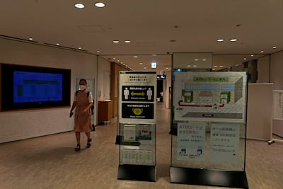 A woman wearing a protective face mask walks past a social distance sign in Osaka, Japan on September 30. Nearly 60 per cent of the Japanese population is now fully vaccinated. Photo: Getty Images