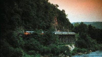 The Eastern and Oriental Express crosses the Kanchanburi Bridge in Thailand.
