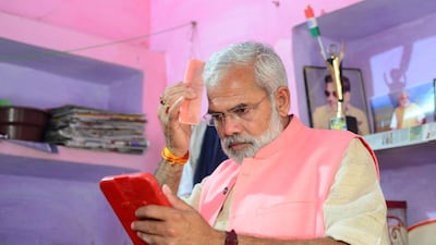 Abhinandan Pathak combs his hair as he campaigns in a national election bid. AFP