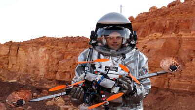 Handling a drone while wearing a spacesuit requires dexterity. AFP