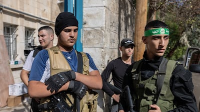 Before a funeral in Jenin refugee camp, resistance fighters gather outside the morgue. Allegiances in the camp are fluid and constantly shift, depending on who is willing to equip and support the fighters