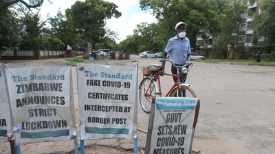 A man walks past posters with newspaper headlines in Harare, Zimbabwe. EPA