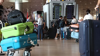 Travellers check the departure board at Ben Gurion International Airport near Tel Aviv. amid the ongoing battles between Israel and Hamas. AFP