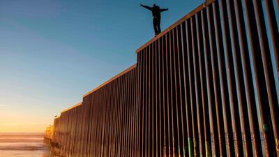 Honduran migrant Jonatan Matamoros Flores, 33, who is traveling with the Central American migrant caravan, climbs the US-Mexico border fence for fun in Tijuana, Baja California state, Mexico. AFP