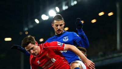 Joe Allen, left, of Liverpool fights for the ball with Kevin Mirallas of Everton during their Premier League match at Goodison Park on February 7, 2015, in Liverpool, England. Clive Brunskill / Getty Images