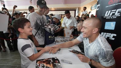 UFC fighter Georges Rush St-Pierre shake hands with a fan at Marina Mall. Jaime Puebla / The National