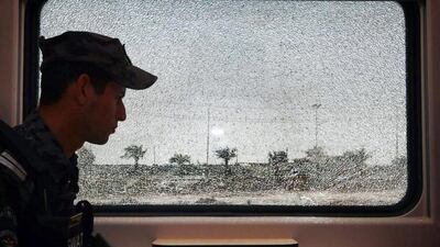 An Iraqi policeman walks past a broken window during a patrol in a passenger car at a railway station in the capital Baghdad as security forces ready a counter-offensive against militants north of the capital. AFP