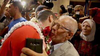 Ahmed Abughaush hugs his father. Raad Adayleh / AP Photo