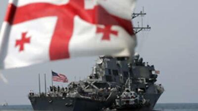 The US McFaul, a guided missile destroyer, is seen behind the Georgian flag after its arrival off shore the port of Batoumi in western Georgia on Aug 24 2008.