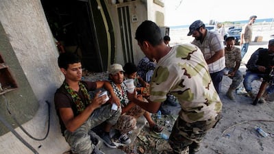 Fighters from Libyan forces allied with the UN-backed Government of National Accord receive meals during a battle with ISIL fighters in Sirte's District 1 neighbourhood on August 17, 2016. Ismail Zitouny/Reuters