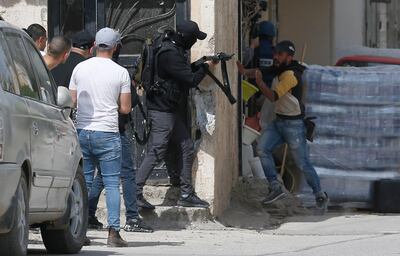 A man takes shelter as a Palestinian militant fires towards Israeli troops during raid inside the Jenin refugee camp on April 9, 2022. EPA