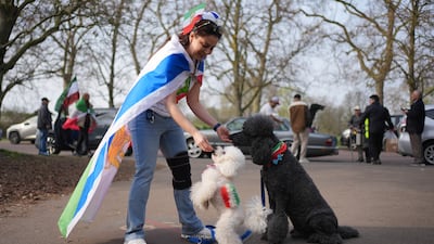 Tannaz Zadeh and her dogs join people outside the Iranian Embassy in London to celebrate the Persian New Year. PA
