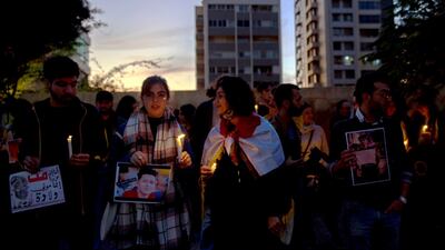 Lebanese activists hold candles during a protest to support children taking part in the uprising in front of the Iraqi embassy in Beirut. EPA