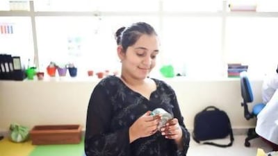 Sara Alam, a pupil with developmental delay, in her classroom with a can of tuna she purchased on her first trip to the grocery store.