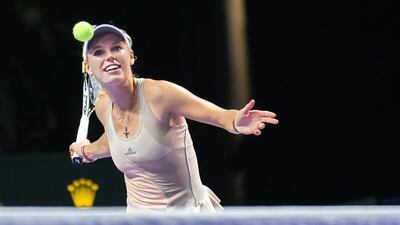 Caroline Wozniacki of Denmark hits a give-away ball to spectators after defeating Petra Kvitova of Czech Republic during the WTA Finals round-robin match at Singapore on Friday. Wozniacki will face Serena Williams on Saturday. Roslan Rahman / AFP