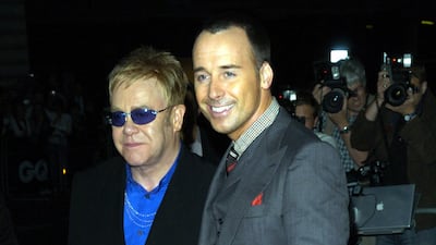 Elton John, in a black suit with a blue flower detail, and David Furnish attend the GQ Men of the Year Awards at the Royal Opera House, London on September 4, 2007. Getty Images