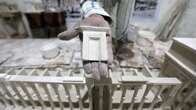 Ali Saleh shows a model of a gate from his wood and plaster model of the famous ancient city of Palmyra, in central Syria. The archaeological site was severely damaged by ISIS extremists who overran the city in 2015. AFP