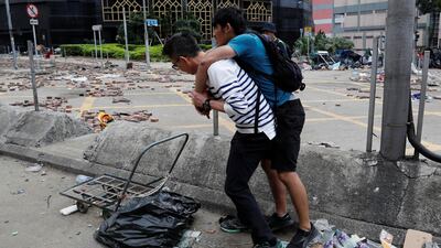 A man carries his son outside the Hong Kong Polytechnic University campus as they wait for an ambulance during protests. REUTERS