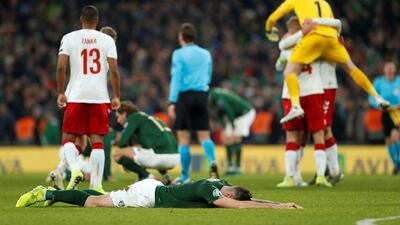 Republic of Ireland players look dejected as Denmark players celebrate at the end of the match. Reuters