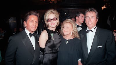 Valentino, US actress Sharon Stone pose on October 25, 1995 in Paris with French actors Jeanne Moreau and Alain Delon during a party organized by Valentino in Maxim's restaurant. AFP