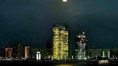 The Abu Dhabi skyline by night: Moody's recently downgraded several of the capital's most important corporations as it feels the lack of explicit government support leaves investors in the dark.