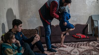 Young patient Mustafa Al Ghanam, whose feet were crushed in the February 6, 2023 quake, performs exercises under guidance of the physio, in Azmarin village, Idlib province. ‘I felt great pain at the beginning after the injury, but I adapted and began to improve with the physical therapy services,’ said Mustafa