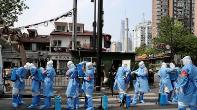 Workers in protective suits prepare to disinfect a residential compound in the Huangpu district of Shanghai, following a coronavirus outbreak. Reuters