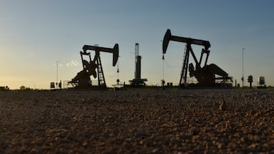 Pump jacks operate in front of a drilling rig in an oilfield in Texas. The IEA expects demand for diesel to fall next year amid record-high prices. Reuters