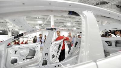 Sales of Tesla’s Model S in China, which begin next month, may match US volume as early as next year. A production supervisor examines a Model S for paint quality at the company’s factory. Noah Berger / Reuters