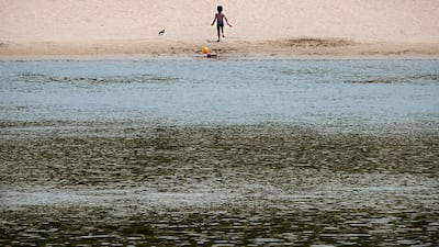 A small child runs on a beach on the banks of the river Danube in Calarasi, southern Romania. AP Photo