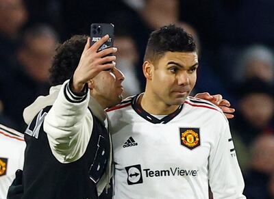 A pitch invader takes a selfie with Manchester United's Casemiro. Reuters